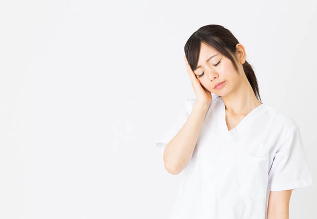 耳を手で押さえている女性
